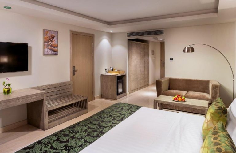 Habitación deluxe con cama doble, sofá y minibar del Centara Muscat Hotel Oman