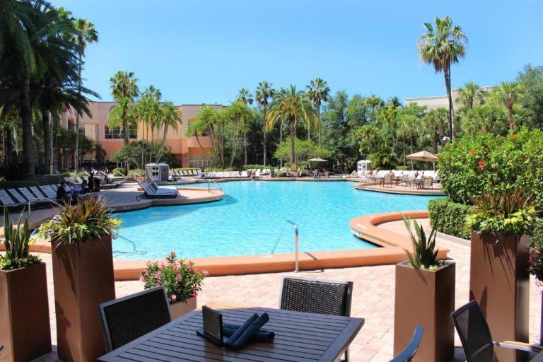 Amplia piscina exterior con tumbonas y palmeras del Rosen Centre Hotel Orlando Convention Center