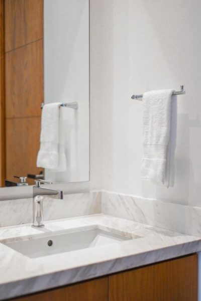 Baño de mármol blanco con lavabo empotrado y toallas blancas en Hotel Puerto Libre