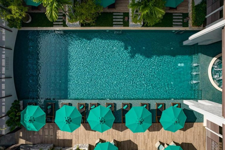 Vista aérea de la piscina exterior con tumbonas y sombrillas turquesa del Maladee Rendezvous Hotel Chiang Mai