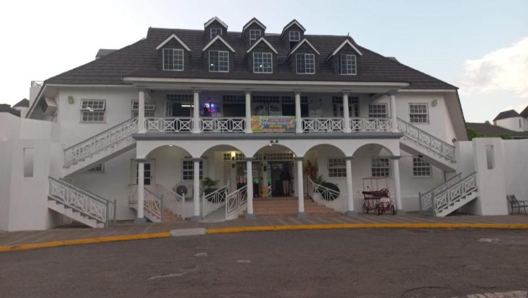 Fachada exterior del Beach Studio 24 at Sandcastles, edificio blanco colonial con balcones y escaleras