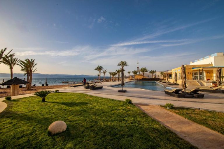Piscina exterior con vistas al mar Rojo y palmeras del Luxotel Aqaba Beach Resort & Spa