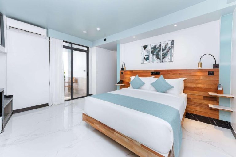 Habitación doble con cama matrimonial y cabecero de madera en el hotel Marukab Plaza