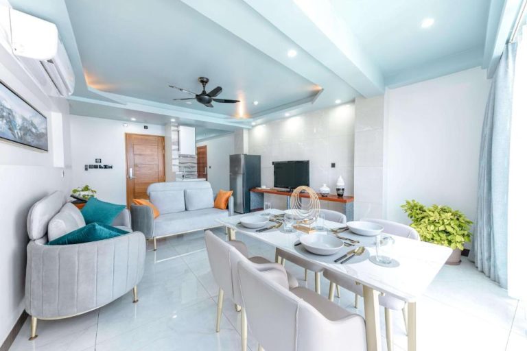 Salón comedor moderno con mesa de mármol y sofás grises en el Marukab Plaza