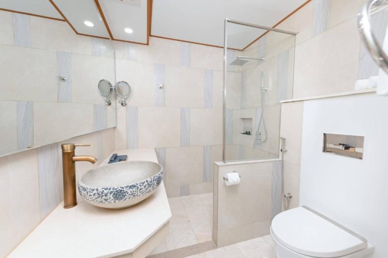 Baño moderno con lavabo de cerámica artesanal y ducha acristalada en el Hotel Marukab Plaza