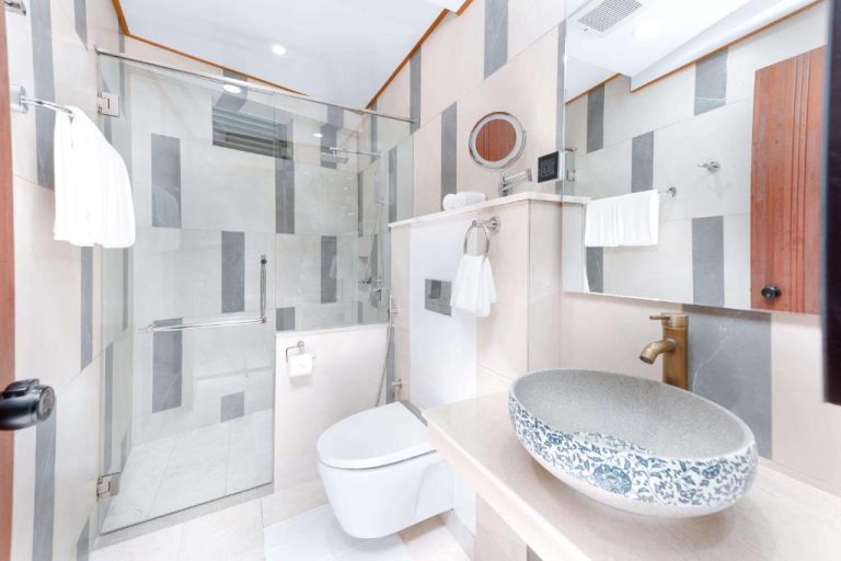Baño moderno con ducha de cristal y lavabo decorativo de cerámica en el Hotel Marukab Plaza