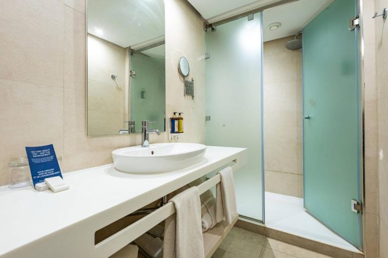 Baño moderno con ducha de cristal y lavabo en el hotel TUI BLUE Medina Gardens Adults Only