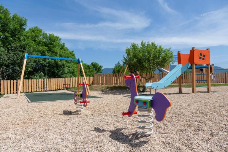 Parque infantil exterior con tobogán, columpios y juegos de muelle en Plitvice Village