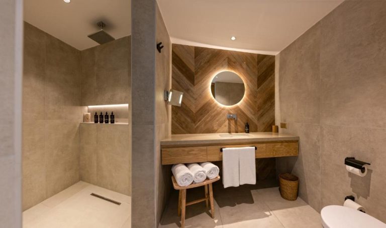 Baño de lujo con ducha lluvia y pared de madera en chevron del Day One Beach Resort & SPA