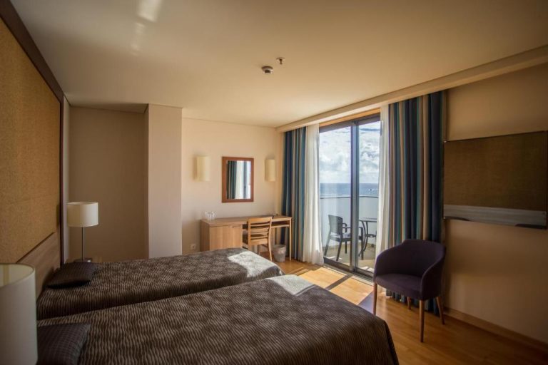 Habitación doble con dos camas y balcón con vista al mar en el Antillia Hotel