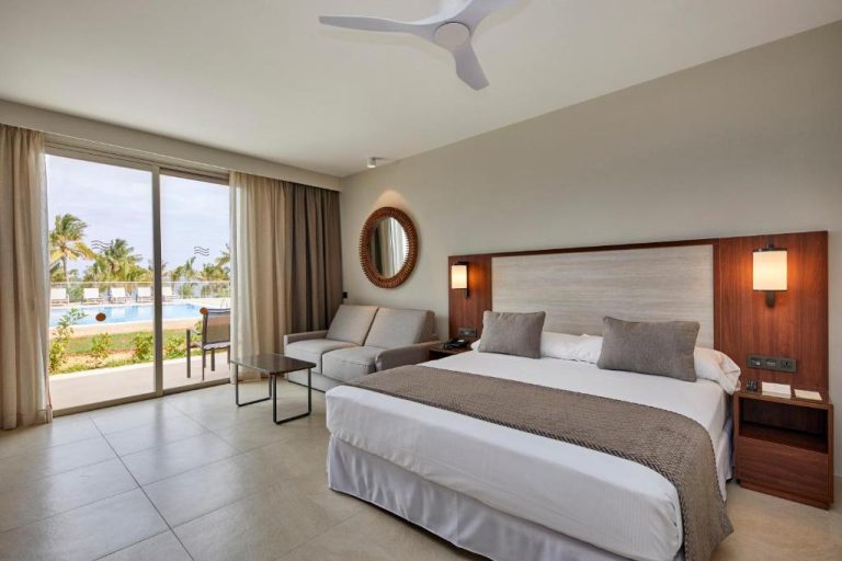 Habitación doble con cama king y vistas a la piscina exterior en el Hotel Riu Jambo All Inclusive