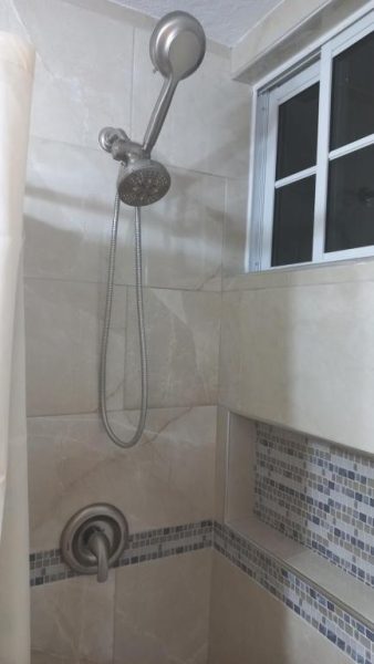 Ducha moderna con telefonillo y baldosas decorativas en Beach Studio 20, apartamento de playa