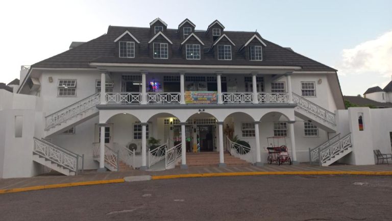 Fachada exterior colonial del Beach Studio 20 con escaleras simétricas y balcón en primer plano