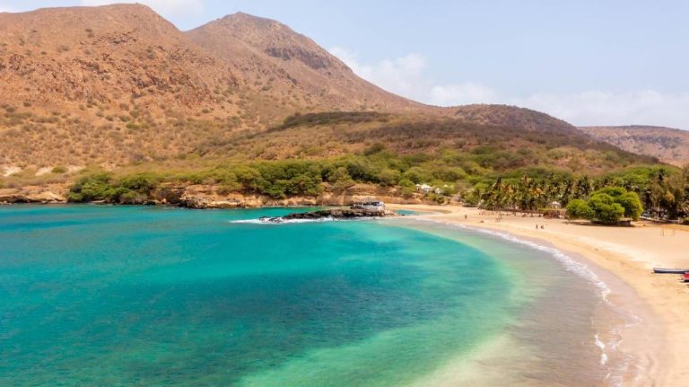 Playa de aguas turquesas con montañas al fondo en Oasis Tarrafal Alfandega Suites, Cabo Verde