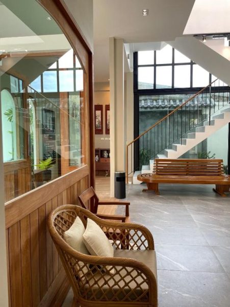 Lobby acogedor con sillones de ratán y escalera del Alleyhill Phuket Boutique Hotel