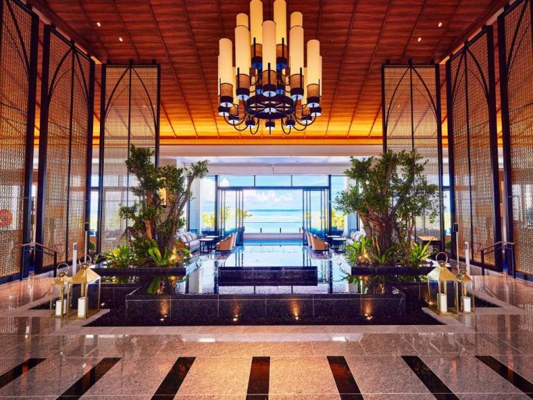 Lujoso lobby del Ryukyu Hotel & Resort Nashiro Beach con fuente, chandelier y vistas al mar