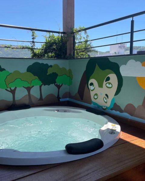 Jacuzzi en terraza con mural artístico decorativo en Hospedaria da Lagoa con vistas al exterior