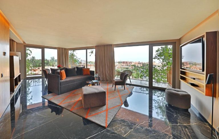 Amplio salón de suite con sofá, suelo de mármol y vistas panorámicas en Hotel Jadali & Spa