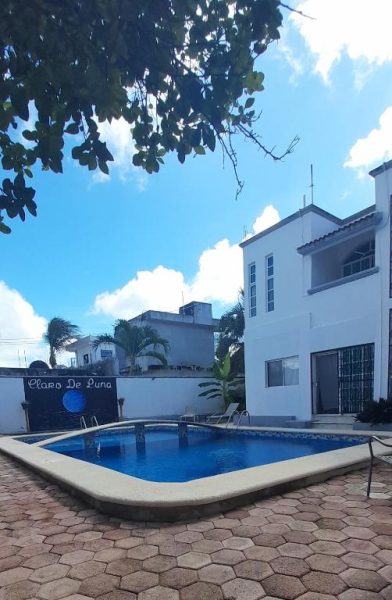 Piscina exterior con terraza de piedra y edificio blanco del Hotel Claro de Luna