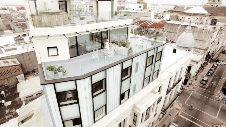 Terraza rooftop con mobiliario blanco y vistas panorámicas de la ciudad en Alma Histórica Boutique Hotel