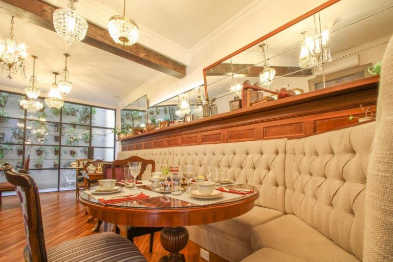 Elegante salón comedor con sofá capitoné y araña de cristal en Alma Histórica Boutique Hotel