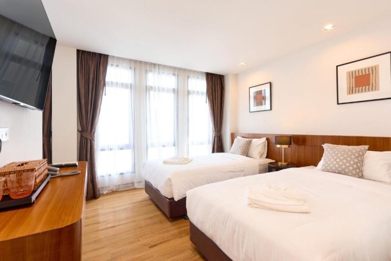 Habitación doble con dos camas y suelo de madera en Be Phrasingh Hotel Chiang Mai