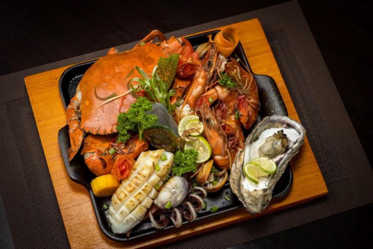Exquisito plato de mariscos con cangrejo, gambas, ostras y calamares en Terrace Green Hotel and Spa