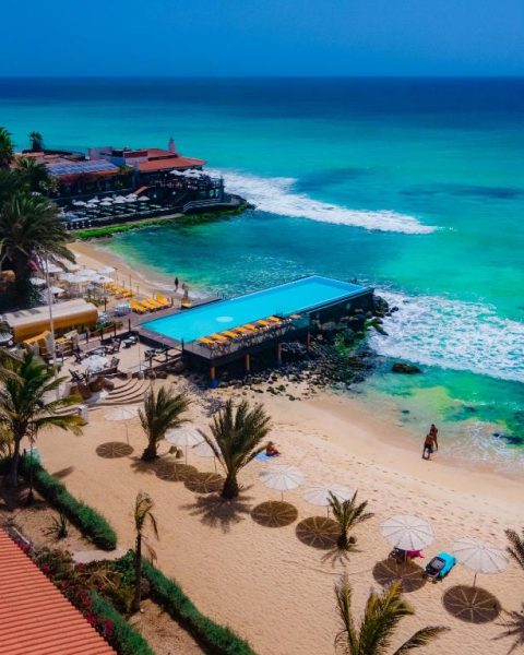 Piscina infinita frente al mar turquesa y playa de arena del Hotel Odjo d'Água en Cabo Verde