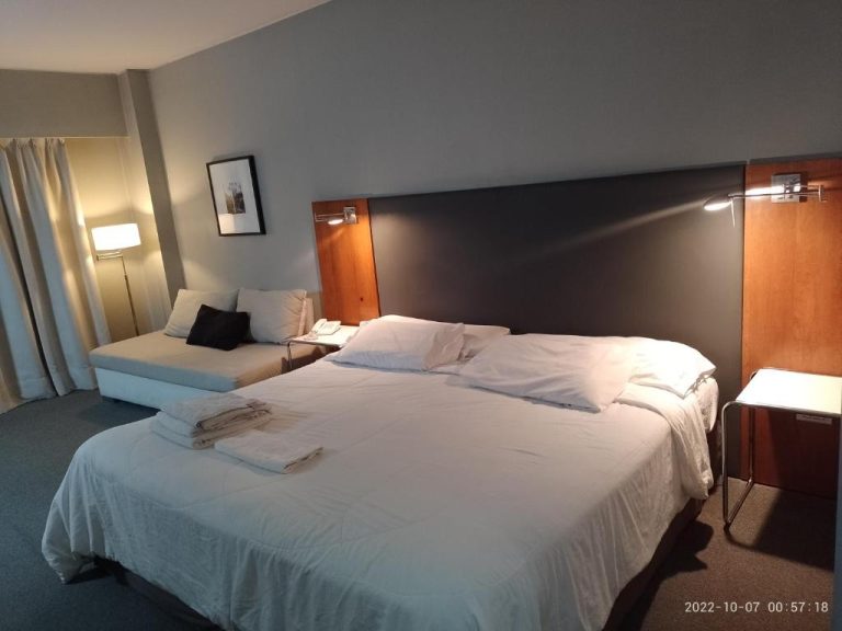 Habitación con cama doble king size y sofá en Buenos Aires Apartamento, decoración moderna