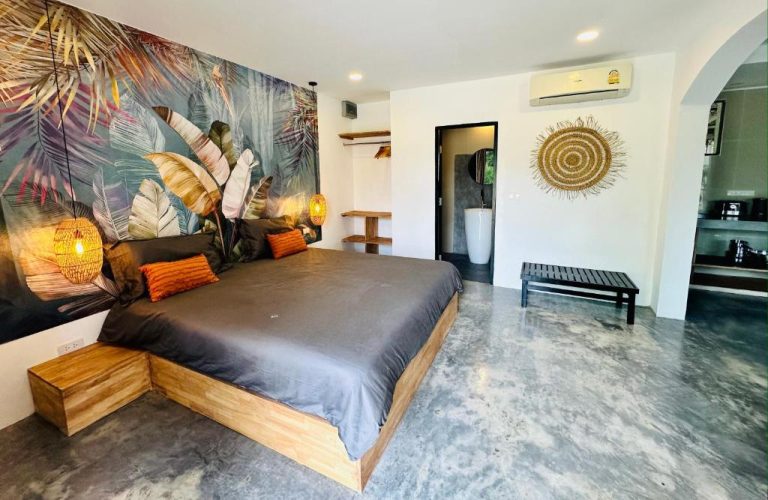 Habitación con cama de madera y mural tropical en Zibá Home Suites, decoración bohemia con iluminación cálida
