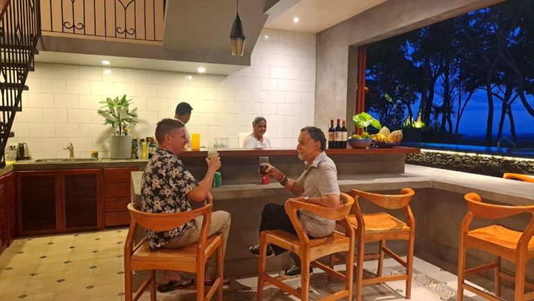 Dos huéspedes brindando en el bar terraza nocturno del Hotel El Guayacán con vistas al jardín