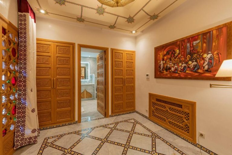 Habitación con puertas de madera tallada y decoración árabe tradicional en La Maison Arabe Hotel Marrakech