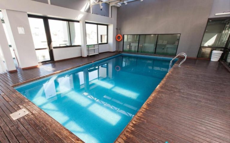 Piscina interior climatizada con deck de madera en Buenos Aires Apartamento, ideal para relajarse