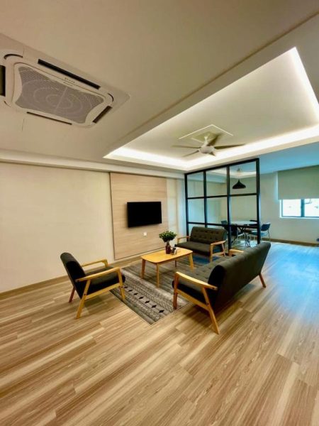 Amplia sala de estar moderna con sofás y TV en Savana Hotel & Serviced Apartments