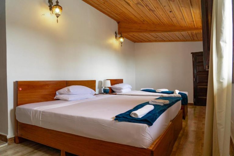 Habitación doble con techo de madera y dos camas en el Hotel Aurelia Zanzibar