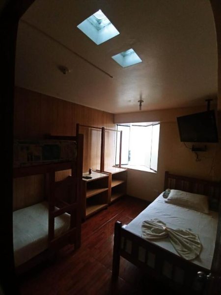 Habitación con litera y cama individual en Hospedaje Del Pilar en Magdalena del Mar con TV y ventana