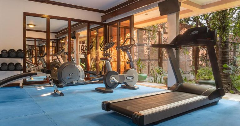 Gimnasio moderno con cintas de correr y bicicletas estáticas en el Angkor Village Hotel de Siem Reap