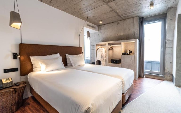Habitación doble con diseño industrial y techo de hormigón en Hotel Cajú