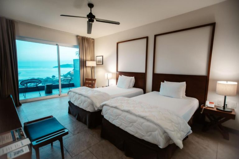 Habitación doble con dos camas y balcón con vista al mar en el hotel Wyndham Tamarindo