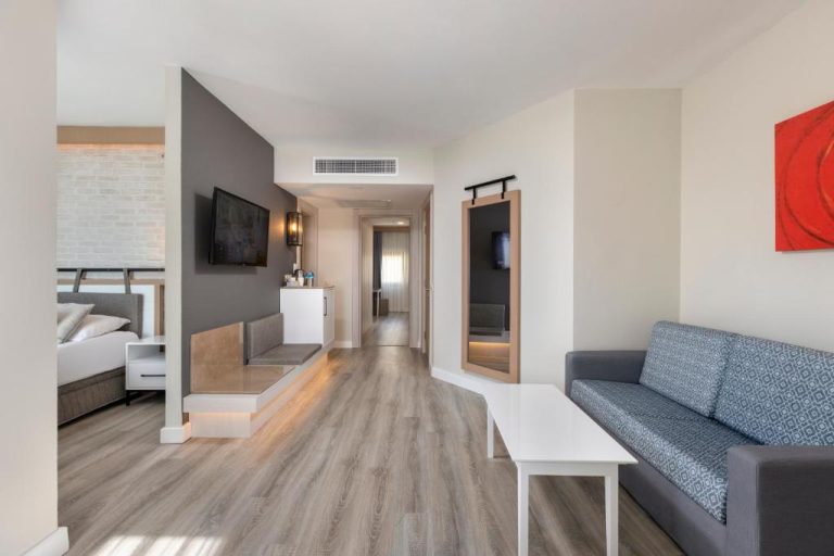 Suite con salón, sofá y zona de dormitorio separada en Limak Arcadia Sport Resort Belek