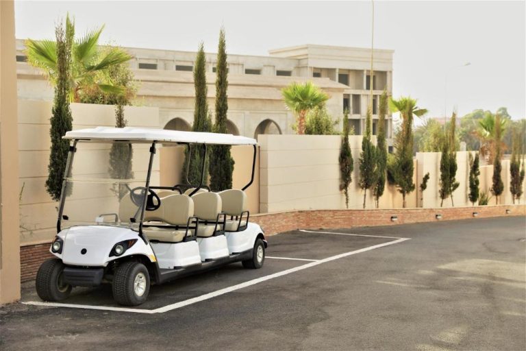 Carrito de golf eléctrico blanco para traslados de huéspedes en el Dominium Residence