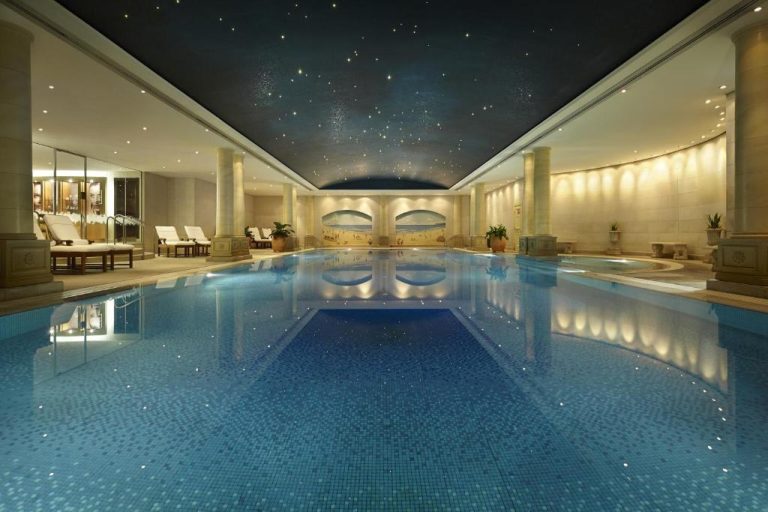 Piscina interior de lujo con techo estrellado y columnas clásicas en The Langham Sydney