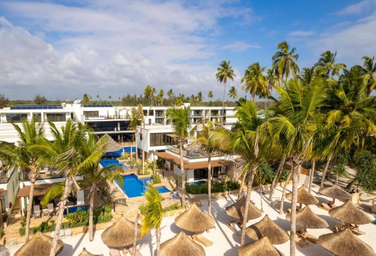 Vista aérea de la piscina exterior y playa con palmeras del TOA Hotel & Spa Zanzibar