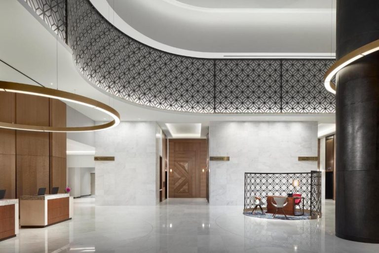 Elegante lobby con recepción de mármol y diseño moderno en Loews Coral Gables Hotel