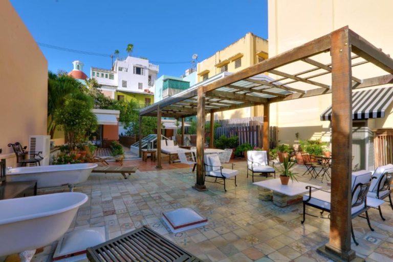 Terraza exterior con pérgola, sillas y bañeras del Villa Herencia Hotel en San Juan