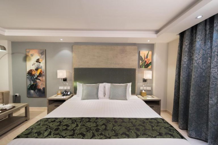 Habitación doble deluxe con cama king size y decoración elegante en Centara Muscat Hotel Oman