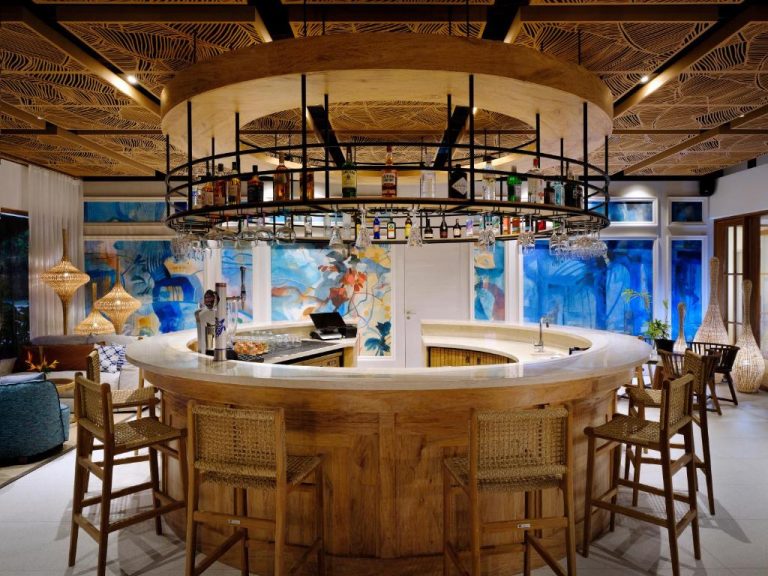 Bar circular de madera con coctelería y decoración tropical en Laïla Seychelles Tribute Portfolio Resort