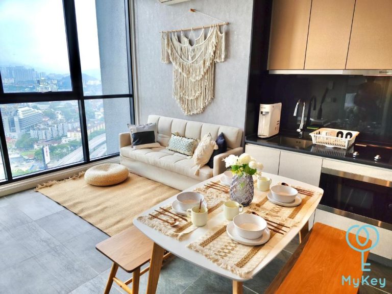 Salón comedor moderno con sofá beige y mesa de madera en Scarletz Suites KLCC con vistas a Kuala Lumpur