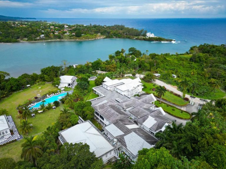 Vista aérea del Jamaica Palace Hotel con piscina exterior y bahía tropical rodeada de vegetación