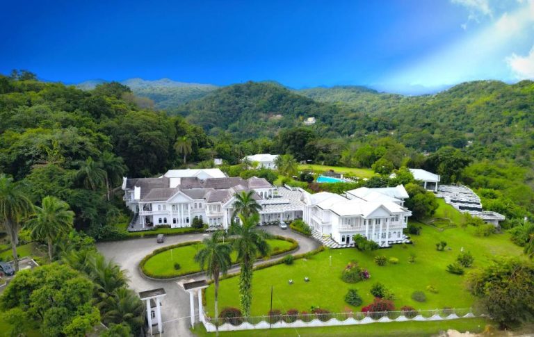 Vista aérea del Jamaica Palace Hotel rodeado de jardines tropicales y montañas verdes en Jamaica